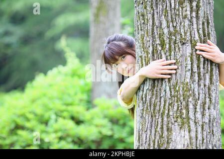 Japanese woman hugging a tree Stock Photo