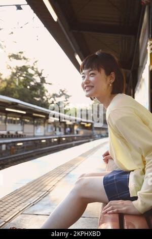 Young Japanese woman waiting for the train Stock Photo - Alamy