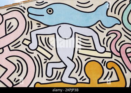 Man carrying a dolphin painted by Keith Haring in Pisa. Detail from a mural named Tuttomondo created outdoor in 1989. Stock Photo