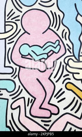 Man with a baby painted by Keith Haring in Pisa. Detail from a mural named Tuttomondo created outdoor in 1989. Stock Photo