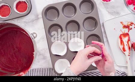 Scooping cupcake batter with a dough scoop into cupcake foil liners to bake  gingerbread cupcakes Stock Photo - Alamy