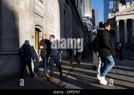 City workers in the afternoon fading light outside the Bank of England, corner of Bank Station as the city carries on through the financial gloom, UK Stock Photo