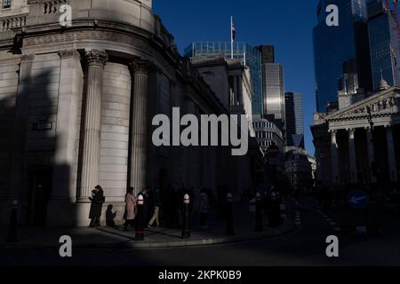 City workers in the afternoon fading light outside the Bank of England, corner of Bank Station as the city carries on through the financial gloom, UK Stock Photo