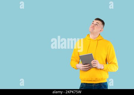 Interesting offer. Thoughtful caucasian guy with tablet pc considering options while making online shopping Stock Photo