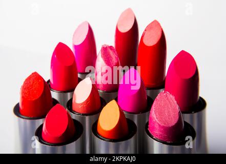 Contemporary fine art still on the heads of multi-coloured lipstick products on white background Stock Photo