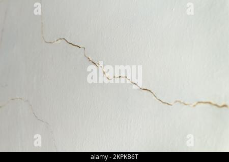 A wall that needs urgent repair. A lot of cracks have formed on old wall in room, which need to be to putty Stock Photo