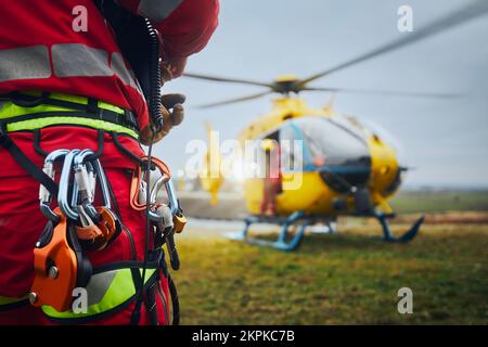 Selective focus on safety harness of paramedic of emergency service in front of helicopter. Themes rescue, help and hope. Stock Photo