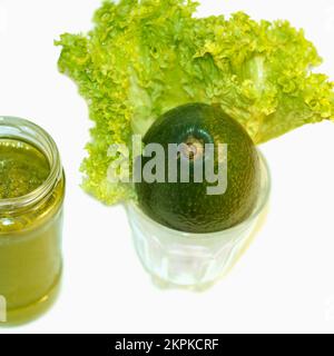 Avocado fruit and smoothie squeezed from avocado and salad leaf on a white background Stock Photo