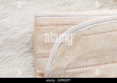 A warm two-sided new electric sheet, lying assembled, on a white background. This is a quick and economical way to heat up in the cold season, in wint Stock Photo