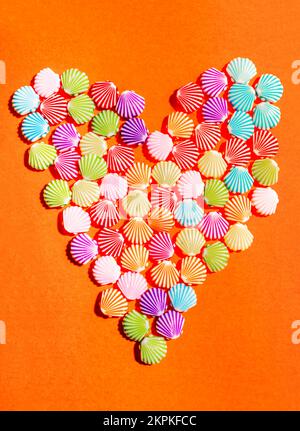 Vibrant colourful art on a formulation of sea shells forming a symbol of marine love. Shelly beach hearts Stock Photo