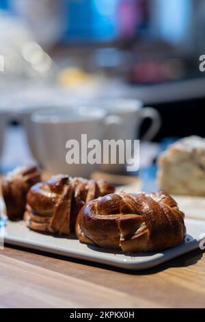 Time for coffee break with cinnamon buns. Coffee and tea cups and cake slices in the background. Photo taken in Sweden. Stock Photo