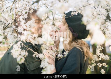 Smiling happy couple standing under a cherry blossom tree in springtime, Belarus Stock Photo