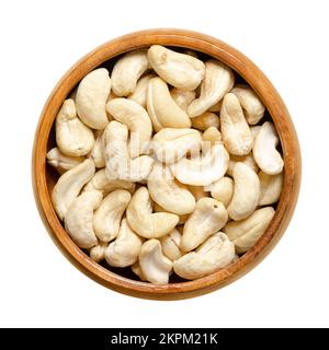 Cashew nuts, raw cashews in a wooden bowl. Seeds of shelled cashew tree fruits, Anacardium occidentale. Snack nuts. Stock Photo