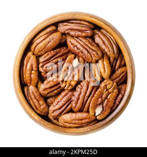 Pecans, raw pecan nut halves in a wooden bowl. Shelled seeds. Pecan tree fruits, Carya illinoinensis. Snack nuts. Stock Photo