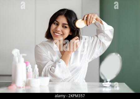 Pretty Woman Combing Her Beautiful Hair With Brush At Home Stock Photo