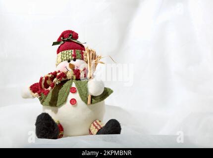 Round and fat snowman decoration with broom and white background Stock Photo