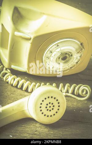 Retro still life domestic disturbances concept on a tipped up rotary landline telephone with disconne cted reciever. Calls unheard Stock Photo
