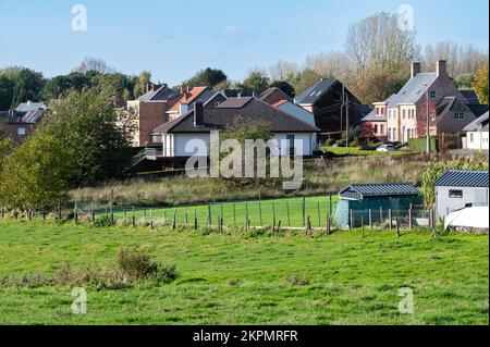 Asse, Flemish Brabant Region, Belgium - 10 20 2022 - Scenic view over green hills and meadows ith residential houses in the background Stock Photo