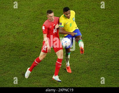 Switzerland's Michel Aebischer (left) and Brazil's Alex Sandro battle for the ball during the FIFA World Cup Group G match at Stadium 974 in Doha, Qatar. Picture date: Monday November 28, 2022. Stock Photo