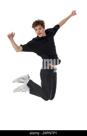 young man in black t-shirt smiling jumping high Stock Photo