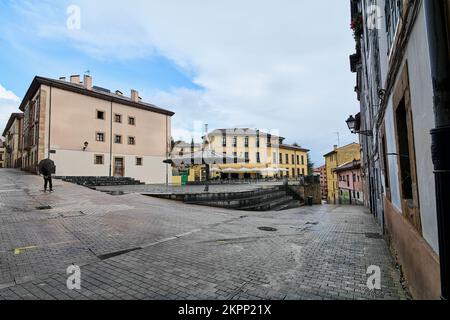 Unrecognizable man with an open umbrella in La Plaza del Paraguas which is a beautiful space located in the historic center of the city of Oviedo in Stock Photo
