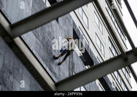 Climbing and painting a skyscraper Stock Photo