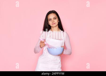 woman holding whisk and bowl with eggs Stock Photo