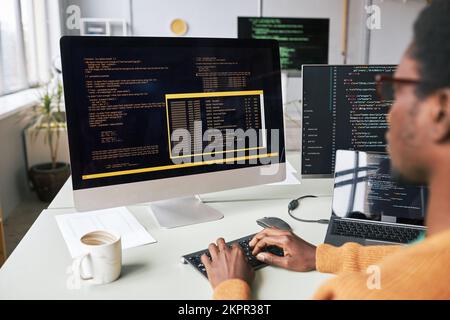 Screen with programming code in front on young software developer Stock Photo