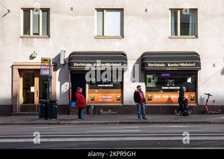 People waiting for a bus in front of Ravintola Karhu Ministeri on Mannerheimintie in Taka-Töölö district of Helsinki, Finland Stock Photo