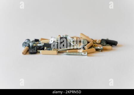 Construction concept. On a white background lies a group of building materials - screws, screws and others. Stock Photo