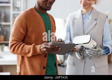 Positive software developer and his colleague testing new app they created for VR headset Stock Photo