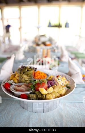 assorted pickled vegetables, tomatoes, cucumbers, mushrooms and potatoes in a plate. Stock Photo