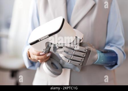 VR headset in prosthetic hand of female scientist Stock Photo