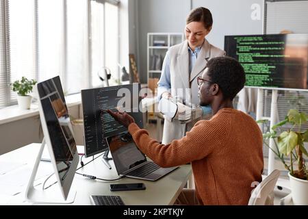 Software developers discussing programming code when working on new application for VR headset Stock Photo