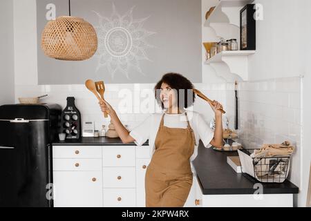 Premium Photo  Cooking utensils. cooking woman in kitchen with frying pan  and wooden spoon. housewife dancing.