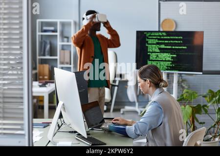 Developer with bionic arm creating software for VR headset Stock Photo