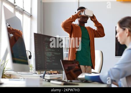 Smiling Black man testing new VR application created by research center worker Stock Photo