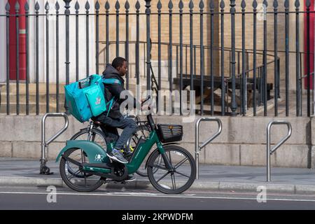 A deliveroo cycle courier riding an e-bike, Waterloo Road, London, UK.  16 Oct 2022 Stock Photo