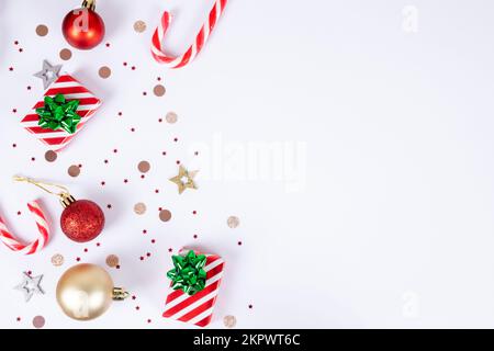 Christmas background with copy space on white backgrounds, decorative elements with candy canes, red and white striped gift boxes and green bows, red Stock Photo