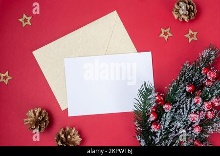 White blank letter to santa claus with empty page and golden envelope on red background top view with fir spruce branch and holly red berries with Stock Photo