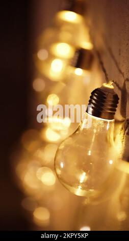 Glowing yellow light bulbs, realistic photo depiction of turning on a tungsten light bulb. Edison lamps in the interior. A garland of light bulbs.Copy Stock Photo