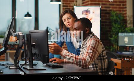 Team of professional developers working on software development with manufacturing interface, infographics. IT engineers brainstorming ideas to develop production with artificial intelligence. Stock Photo
