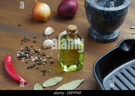 Empty Grill pan and various spices and seasonings, spices and olive oil on a wooden table close-up. Outdoor cooking concept Stock Photo