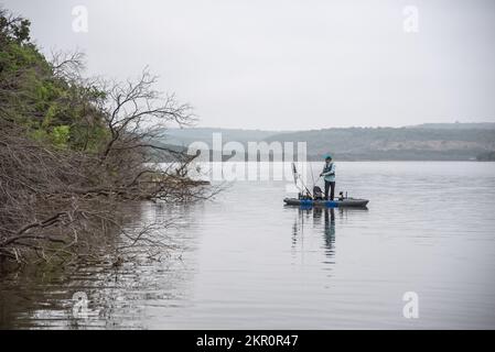 Kayak Angler bass fishing laydowns on Possum Kingdom Lake in Texas Stock Photo