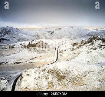 Snowy road between mountains in winter Stock Photo