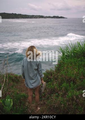 Young woman at ocean coastline Stock Photo