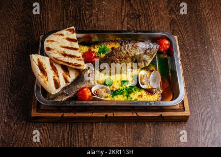 baked dorada with vegetables and seafood Stock Photo
