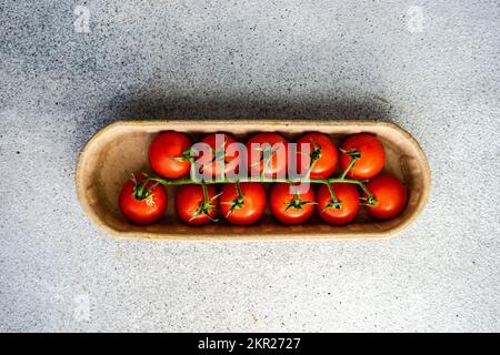 Overhead view of  cherry vine tomatoes in a cardboard carton Stock Photo