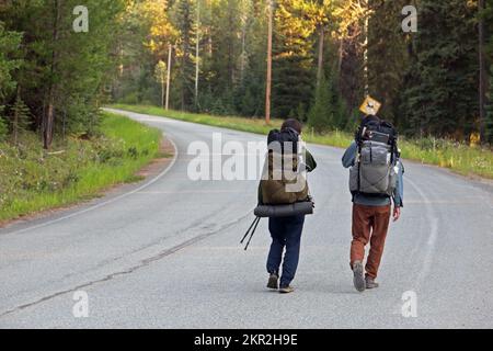 Young couple from Japan thru hiking the Pacific Northwest National Scenic Trail are road walking through Yaak Valley Montana. (Photo by Randy Beacham) Stock Photo