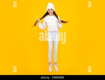 Full length overjoyed teenager kid girl 12 13 14 year jumping old isolated on yellow background studio. Funny jump. Children lifestyle childhood Stock Photo